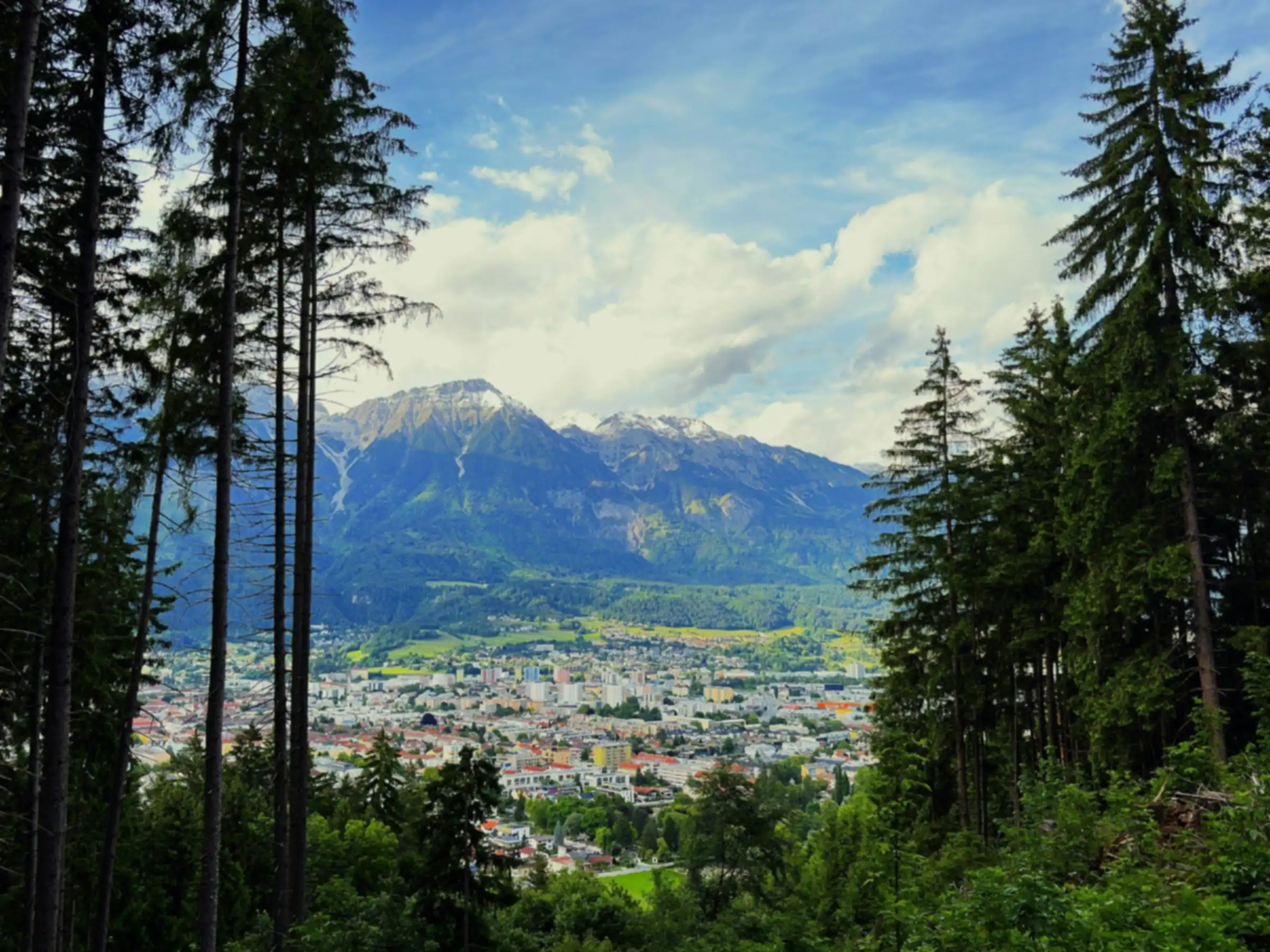 Blick vom Waldrand auf [Nachbarort B] vor den Bergen [eigenes Ortsfoto einsetzen]