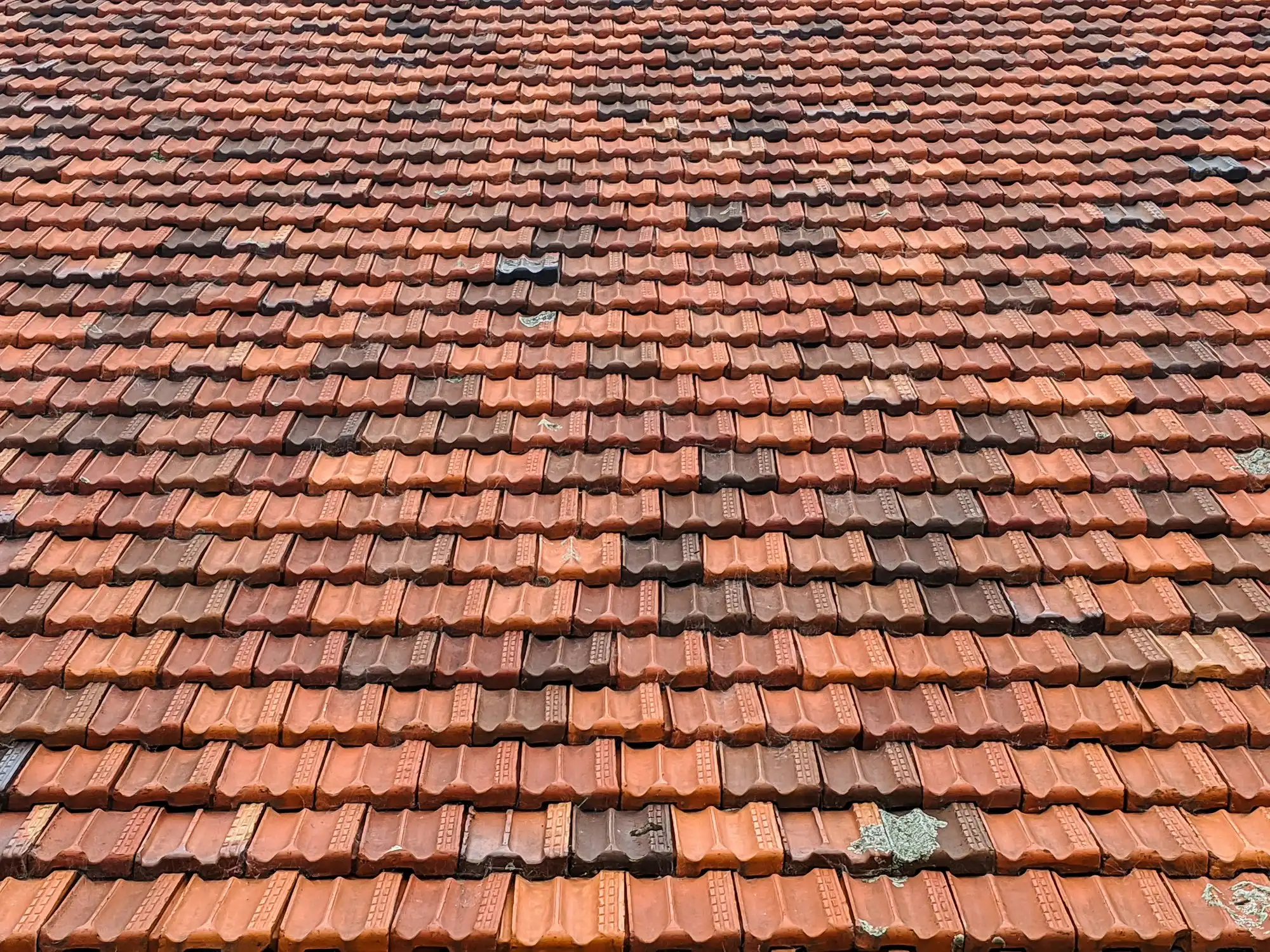 Verwitterte Dachziegel mit Rissen, wie sie Kunden oft per Foto schicken